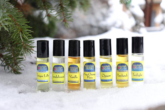 Set of small Moonlight Rose Perfume oil bottles with labels on a snowy background